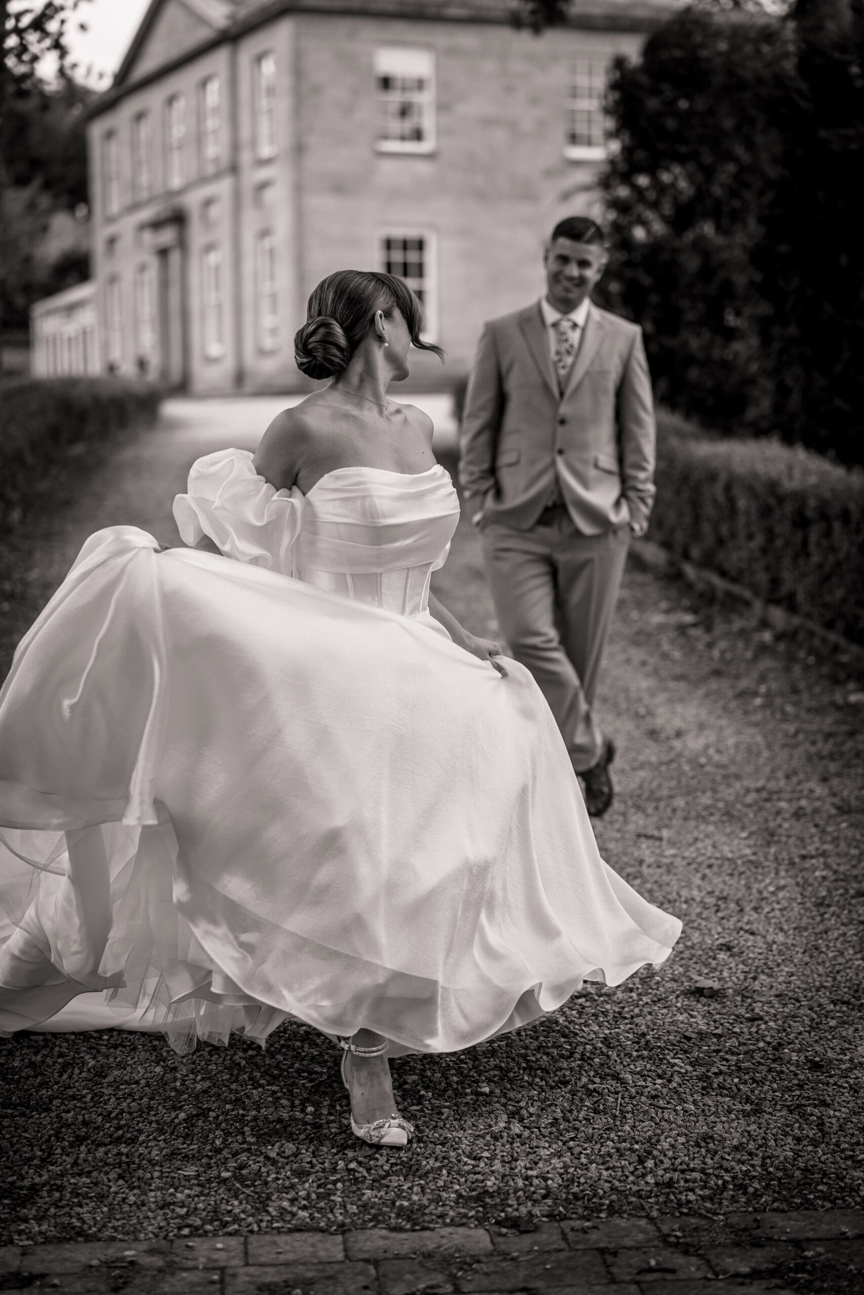 A bride walking away from her groom in black and white with the dress flowing high at grassfield harrogate | Yorksire wedding photographer